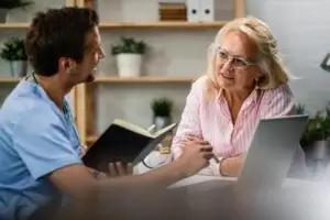 Doctor discussing care options and budgeting for a caregiver in Toronto with an elderly woman.
