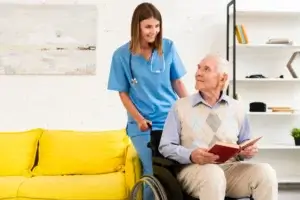 Caregiver assisting an elderly man in a wheelchair, showing compassion and support in home care.