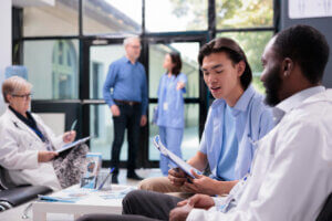 Diverse nurse and elderly patient smiling during a home care visit, showing respect and cultural understanding.
